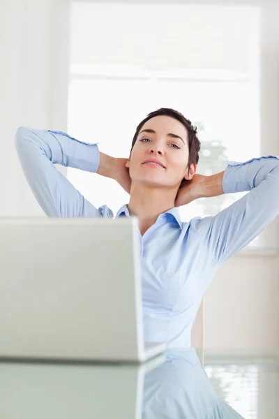Entspannte Geschäftsfrau mit Laptop, die in die Kamera blickt — Stockfoto