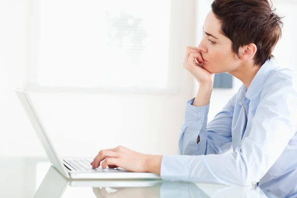 Uttråkad korthårig affärskvinna med en bärbar dator — Stockfoto