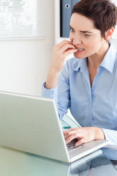 Bir dizüstü bilgisayar ile sinirli iş kadını — Stok fotoğraf