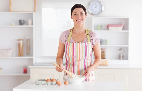 Short-haired brunette woman preparing a cake — Stock Photo, Image