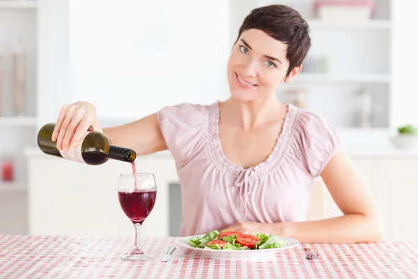 Frau gießt Rotwein in ein Glas — Stockfoto