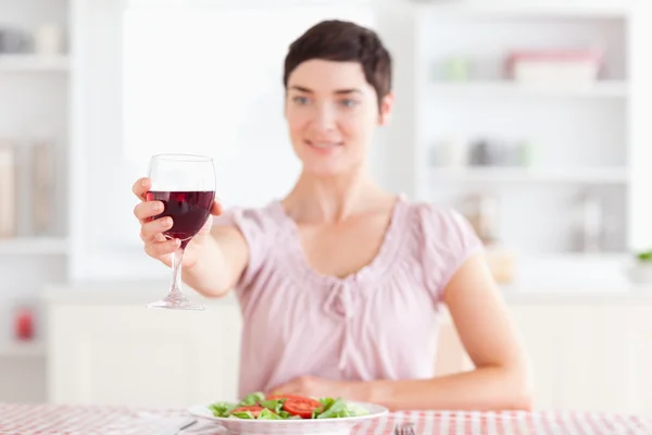Lächelnde brünette Frau, die mit Wein anstößt — Stockfoto
