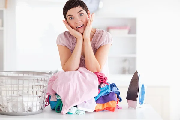 Mulher surpresa com uma pilha de roupas — Fotografia de Stock