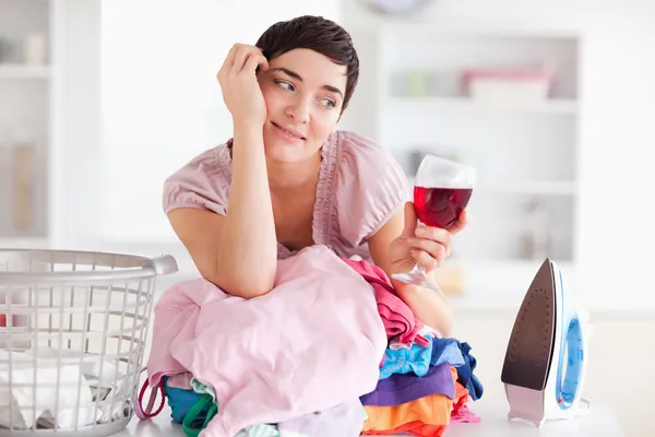 Cute Woman with wine and a pile of clothes — Stock Photo, Image