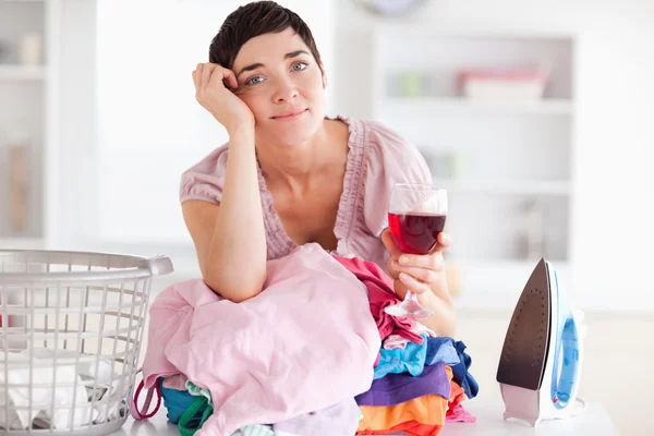 Sad Woman with wine and a pile of clothes — Stock Photo, Image