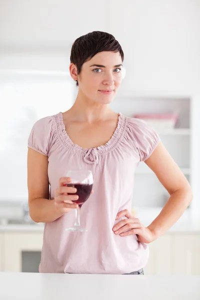 Frau mit einem Glas Wein blickt in die Kamera — Stockfoto