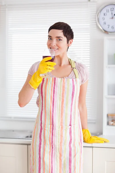 Leende kvinna i rengöring klänning med vin — Stockfoto