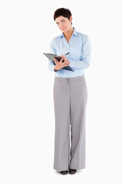 Businesswoman writing on a clipboard — Stock Photo, Image