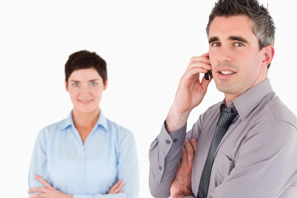 Businessman making a phone call while his colleague is posing — Stock Photo, Image