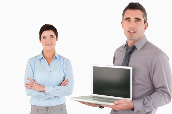 Kantoor werknemer weergegeven: een laptop terwijl zijn collega is poseren — Stockfoto