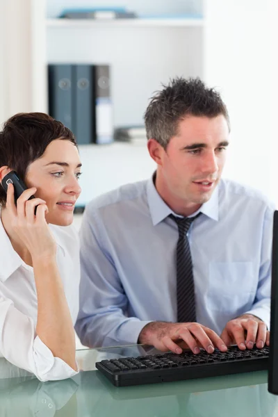 Portrait of a woman telephoning while her colleague is using a c — Stock Photo, Image