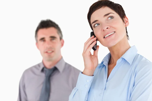 Vrouw waardoor een telefoongesprek, terwijl haar collega is poseren — Stockfoto
