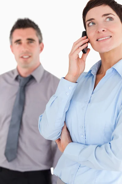 Retrato de uma mulher em um telefonema enquanto seu colega está posin — Fotografia de Stock