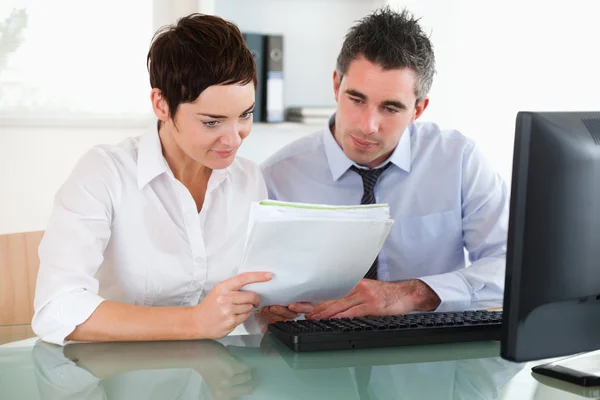 Female and male workers looking at a document — Stock Photo, Image