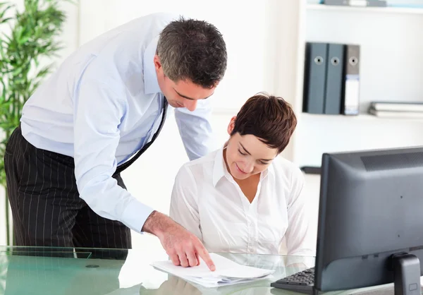 Business manager showing something on a document to his secretar — Stock Photo, Image
