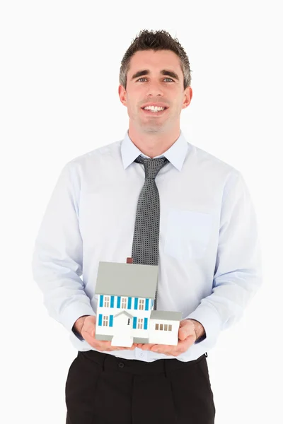 Podnikatel drží miniaturní dům — Stock fotografie