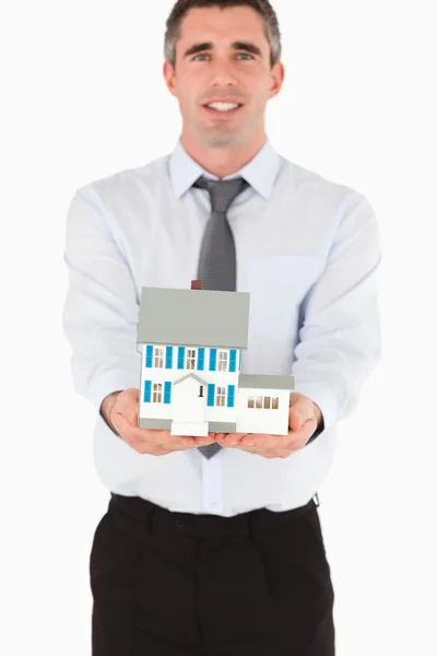 Агент по недвижимости показывает миниатюрный дом — стоковое фото