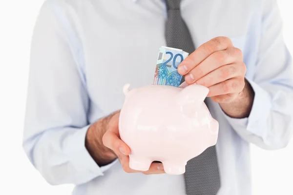 stock image Close up hands putting a bank note in a piggy bank