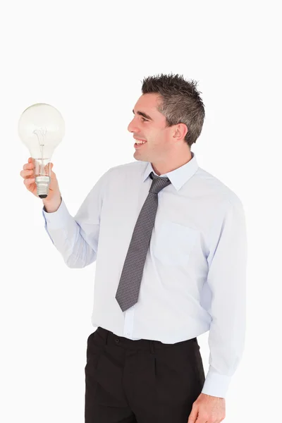 Man looking at a light bulb — Stock Photo, Image