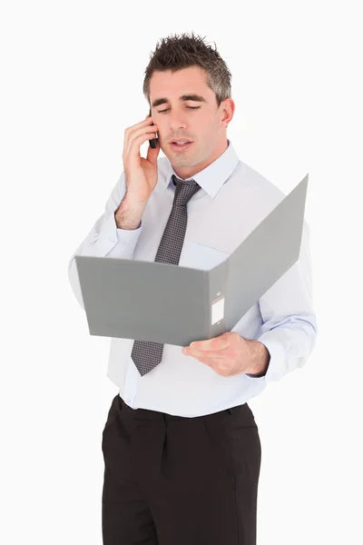 Porträtt av en affärsman som att göra ett telefonsamtal medan du håller en bi — Stockfoto