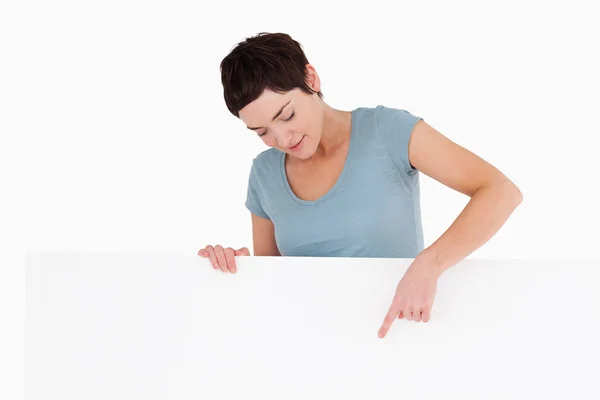 Женщина указывает на пространство для копирования на панели — стоковое фото