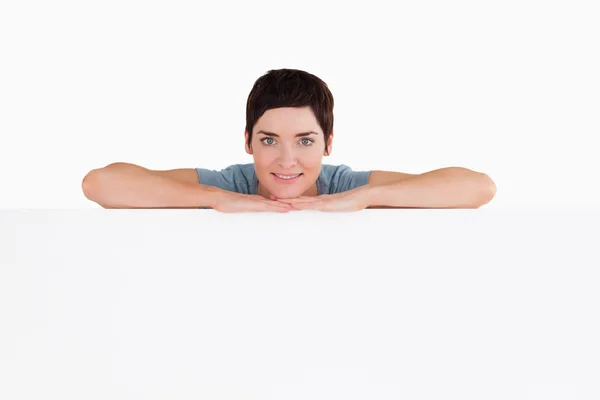 Vyrovnaná žena spoléhat na prázdný panel — Stock fotografie