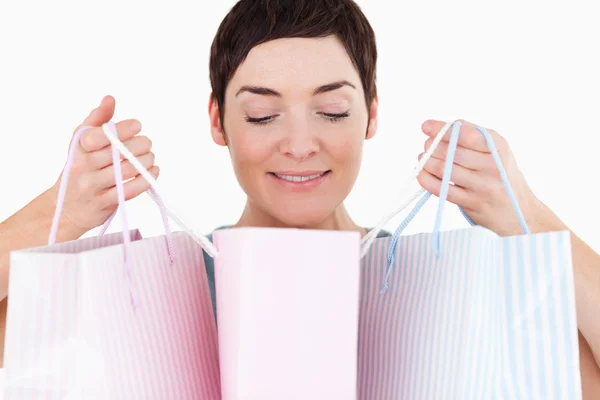 Mulher olhando para seus sacos de compras — Fotografia de Stock
