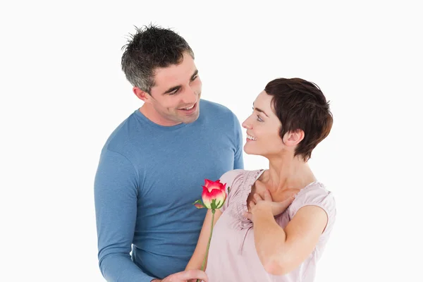 Муж, предлагающий розу своей довольной жене — стоковое фото