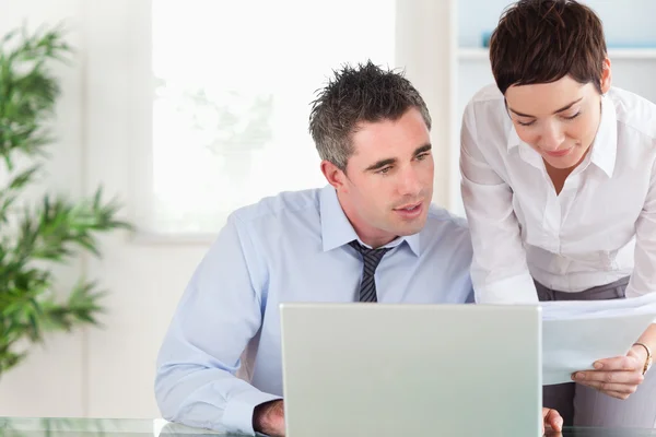 Office workers comparing a blueprint document to an electronic o — Stock Photo, Image