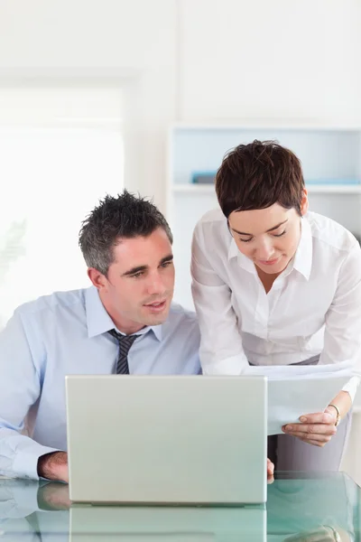 Portrait of colleagues comparing a blueprint document to an elec — Stock Photo, Image