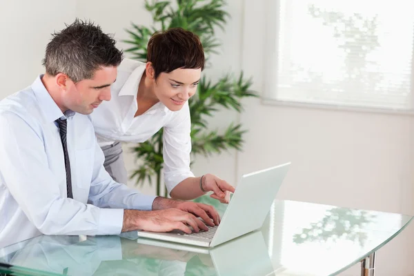 Businesswoman pointing at something to her colleague on a laptop — Stock Photo, Image