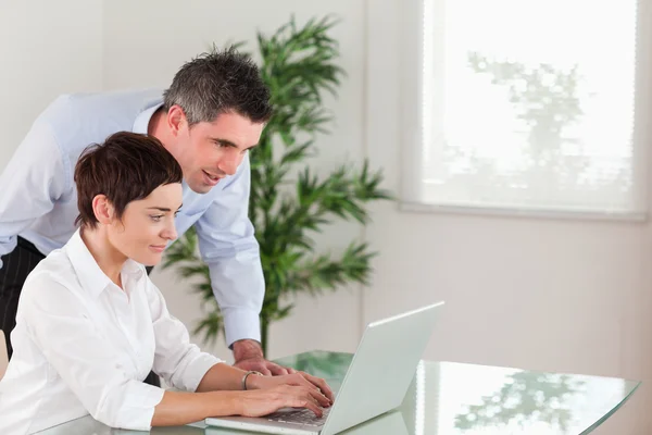 Gerente e sua secretária trabalhando com um laptop — Fotografia de Stock