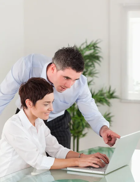 Retrato de um gerente e sua secretária trabalhando com um laptop — Fotografia de Stock
