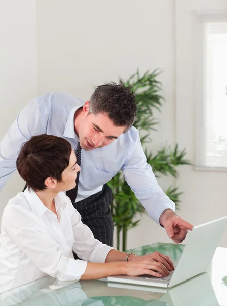Portrait of a manager pointing at something to his secretary on — Stock Photo, Image