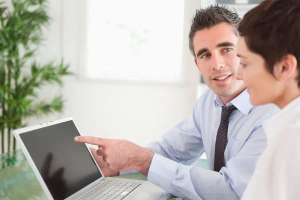 Manager pointing at something to his secretary on a laptop — Stock Photo, Image
