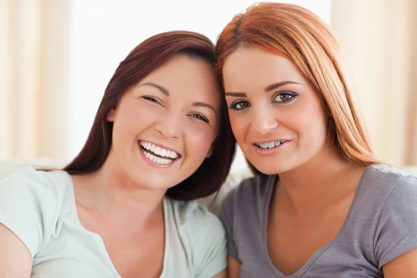 Hermosos amigos sentados en un sofá — Foto de Stock