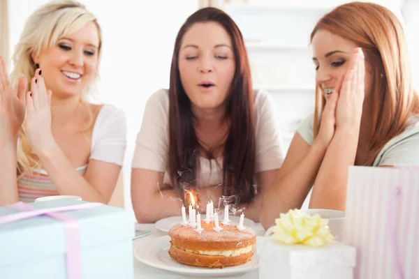Vackra kvinnor sitter vid ett bord med en tårta — Stockfoto