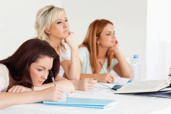 Bored students sitting at a table — Stock Photo, Image