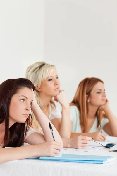 Bored university students sitting at a table — Stock Photo, Image