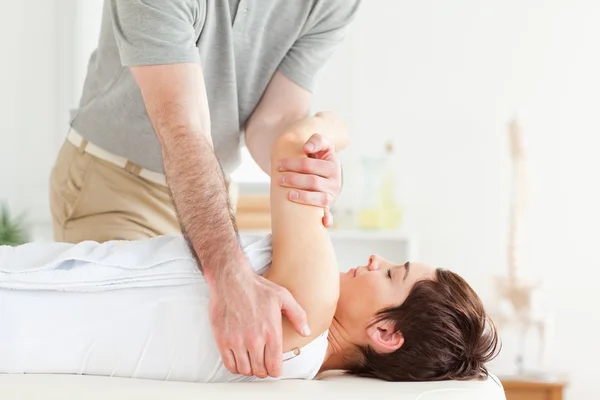 Man stretching a woman's arm — Stock Photo, Image