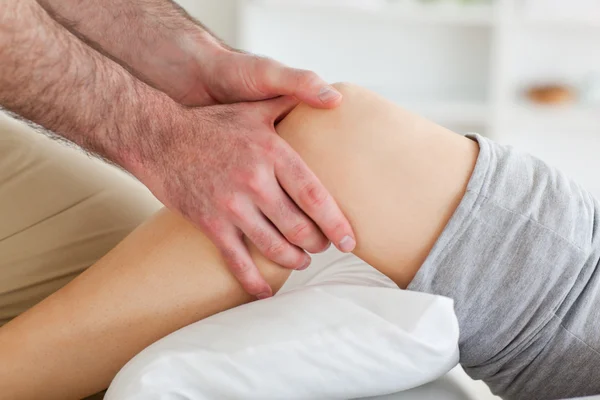 Homem massageando o joelho de uma mulher — Fotografia de Stock