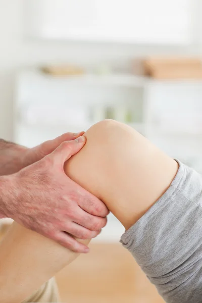 Guy masseren een liegen vrouw knie — Stockfoto