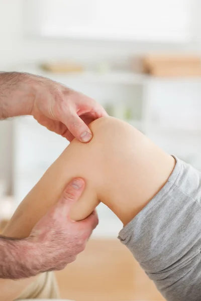 Guy massaging a knee — Stock Photo, Image