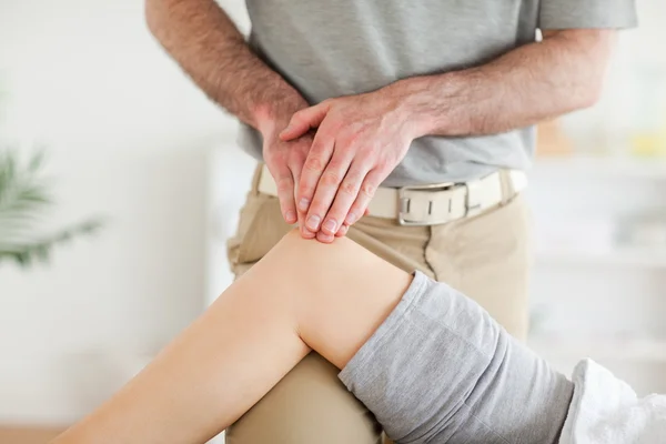 Chiropracteur massant le genou d'une jolie femme — Photo