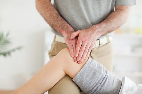 Quiroprático massagear o joelho de uma mulher encantadora — Fotografia de Stock