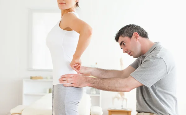 Chiropractor examining a cute woman's back — Stock Photo, Image