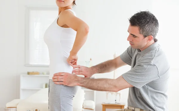 Chiropractor examining a charming woman's back — Stock Photo, Image