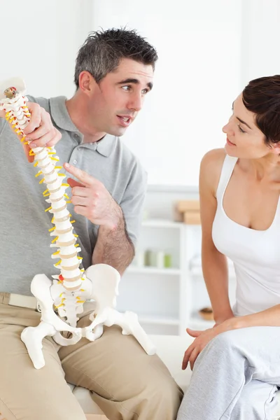 Chiropractor uit te leggen van de wervelkolom aan zijn patiënt — Stockfoto