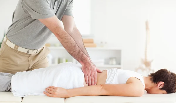 Homem massageando as costas de uma mulher bonita — Fotografia de Stock