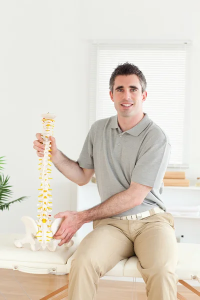 Holding model omurga kameraya bakarak chiropractor — Stok fotoğraf